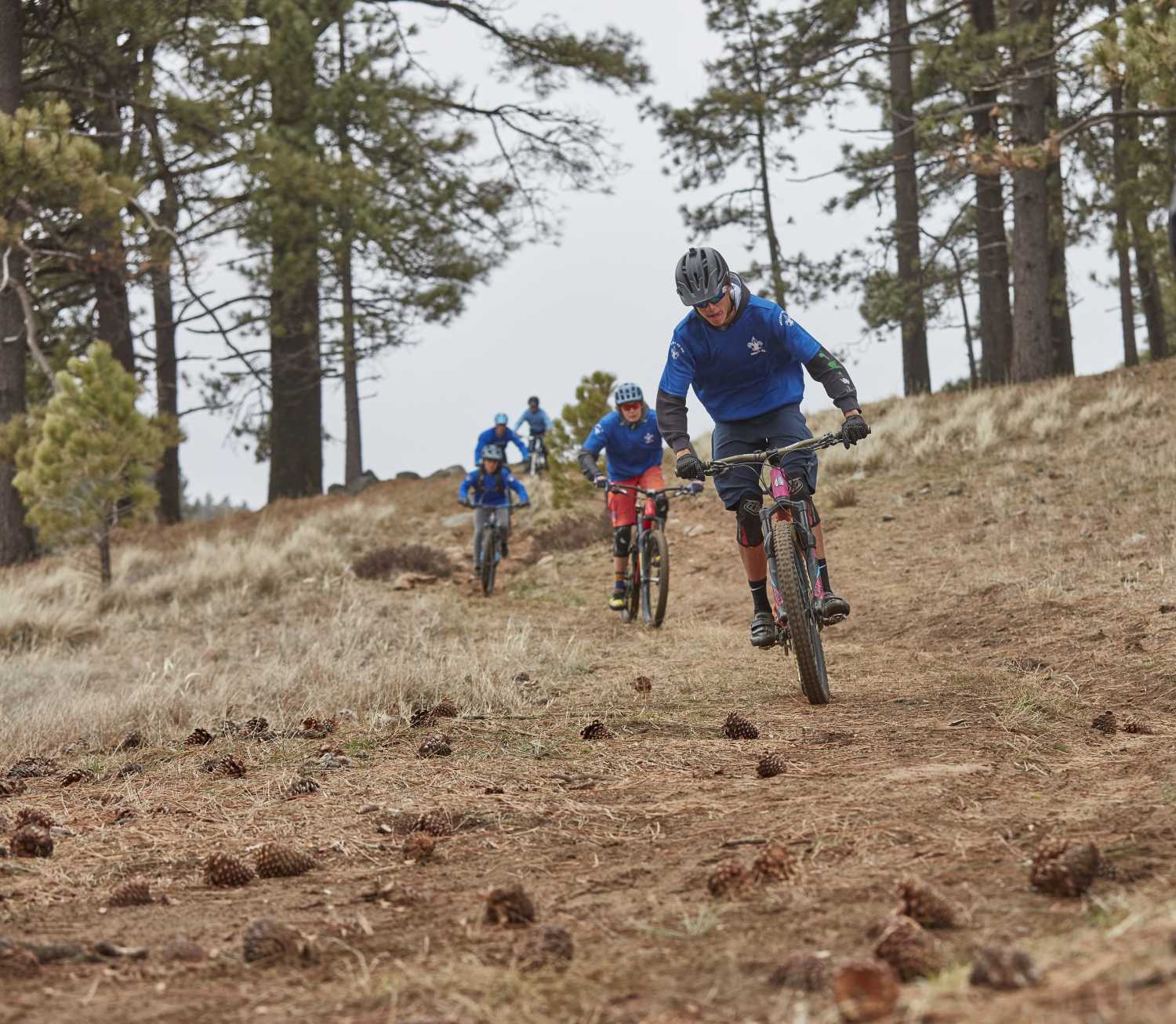 Scouts ride mountain bikes through the woods